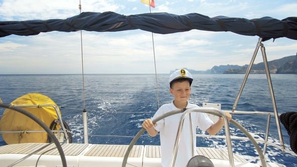 Litle Children Captain at the Helm Controls of a Sailing Yacht During Race alt