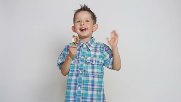Cute Happy Child, Eating Ice Cream, Holding a Stick and Smiling Into the Camera