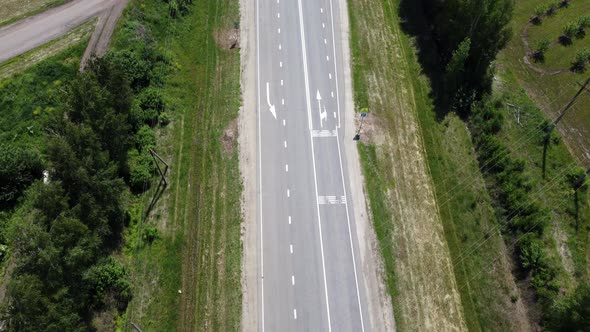 Car Driving Along the Highway in the Woods on a Summer Day