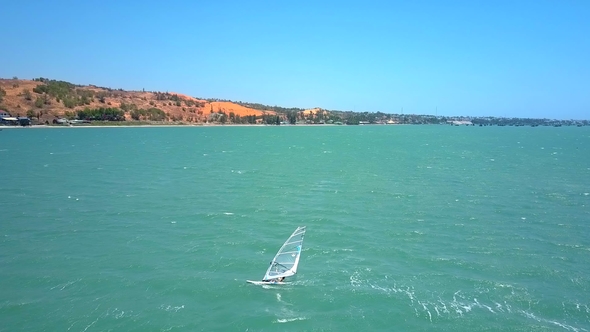 Surfer Fights with Wind Against Coast Landscape alt