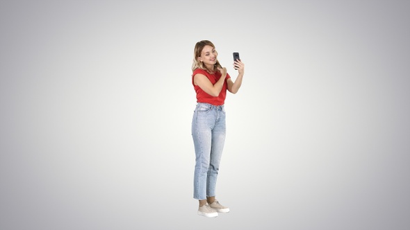 Blonde woman preening in front of the smartphone on gradient alt