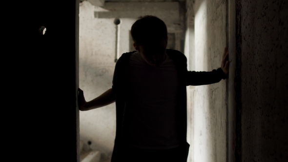 Yound Bad Looking Man Leans Against the Walls in an Abandoned Building alt