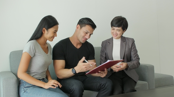 Young Attractive Couple Meeting Real-estate Agent, Signing Contract with Female Broker