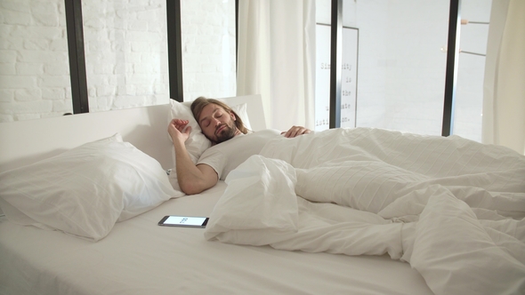 Wake Up. Man Sleeping In Bed With Phone Alarm