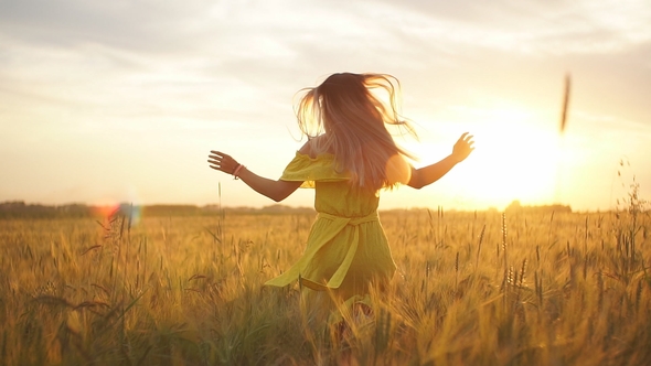 A Girl in a Red Dress Runs Across the Field at Sunset, Stock Footage