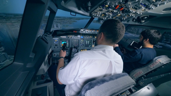 Airplane Pilot Instructor and a Man Are Managing Flight Simulation Process alt