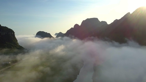 Tranquil River in Valley Covered with Fog Against Hills