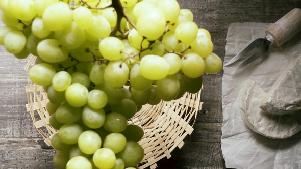 A Bunch of Grapes Falls Into the Basket on the Table Top View