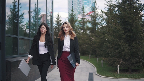 Business Portrait of Two Young Women on the Background of a Modern Building