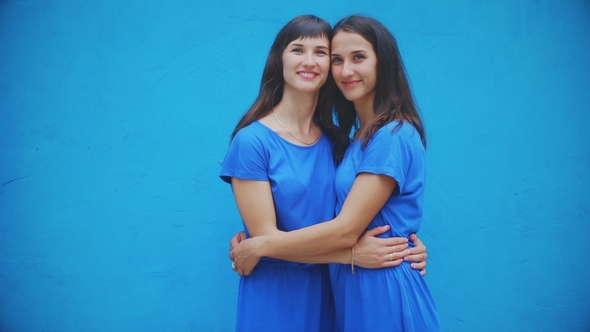 Girls Twins Posing , Smiling Over Blue Background