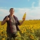 Man Farmer Hand Hold Bottle of Sunflower Oil the Field at Sunset - VideoHive Item for Sale