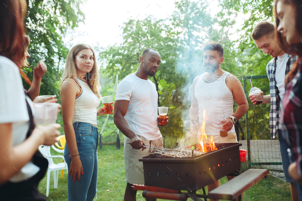 Group of friends making barbecue in the backyard. concept about good and positive mood with friends Stock Photo by master1305