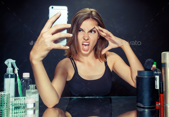 Beauty woman with makeup. Beautiful girl looking at the mobile phone and making selfie photo - Stock Photo - Images