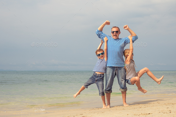 Father and children playing on the beach at the day time. - Stock Photo - Images