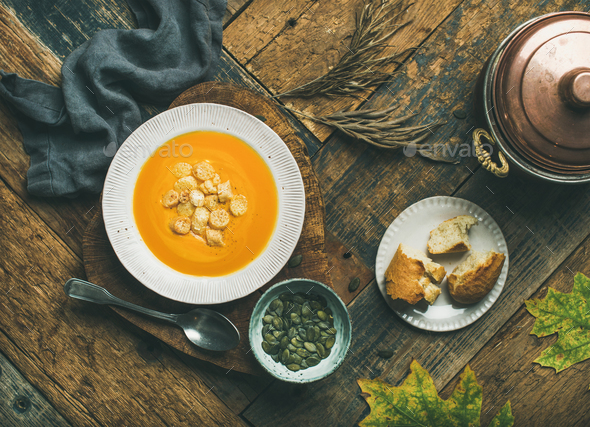 Warming pumpkin cream soup with croutons and seeds - Stock Photo - Images