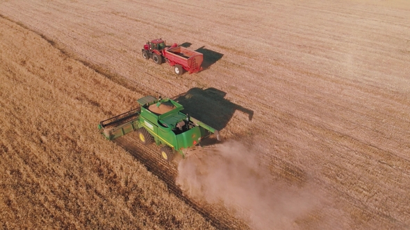 Aerial Drone Shot of a Combine Harvester Working in a Field at sunset ...