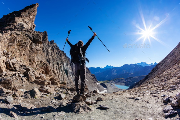 Hiker reaches a high mountain pass - Stock Photo - Images