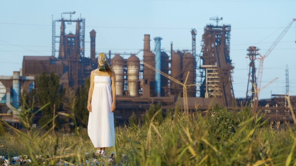 Woman in a Gas Mask on a Background of Smoky Pipes of a Factory alt