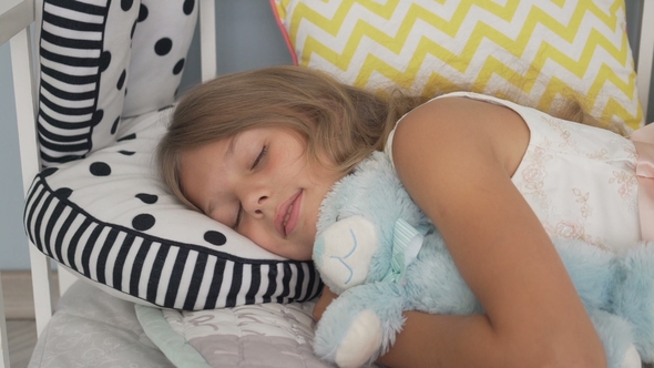 Cute Little Girl Sleeping with Teddy Bear in Bed