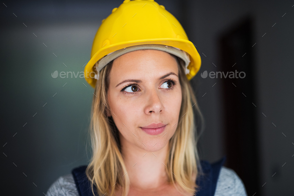 Young woman worker with a yellow helmet on the construction site. Stock Photo by halfpoint
