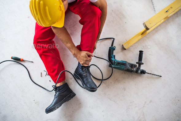 An accident of a man worker at the construction site. Top view. Stock Photo by halfpoint