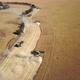 High sweeping view of combines working as a team to harvest corn on a huge farm - aerial - VideoHive Item for Sale