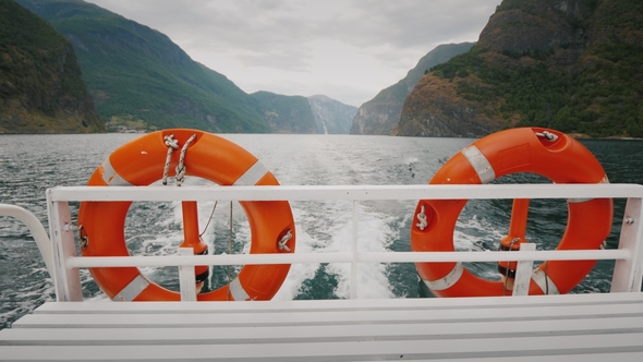 Cruise Ship Cruise with Two Lifebuoys. In the Background, the Picturesque Norwegian Fjord alt
