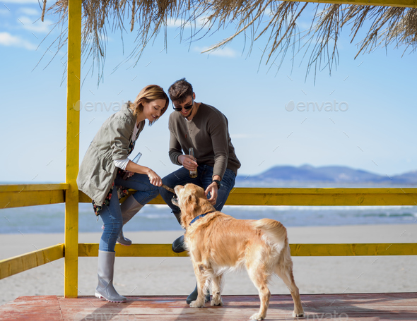 young couple with a dog at the beach