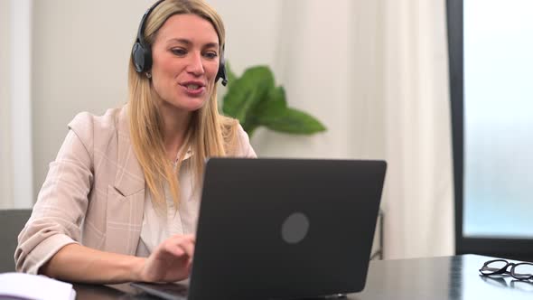 Young Female Call Center Operator with Handsfree Headset Talking with Client