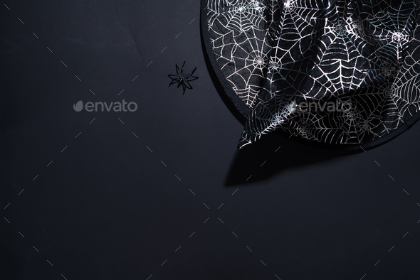 Black witch hat with a pattern of cobwebs on black background - Stock Photo - Images