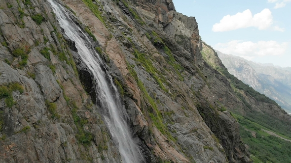 Tracking and Top Shot Air Shot From a Stream of Water Splashing Waterfall on a Rock Wall in the alt