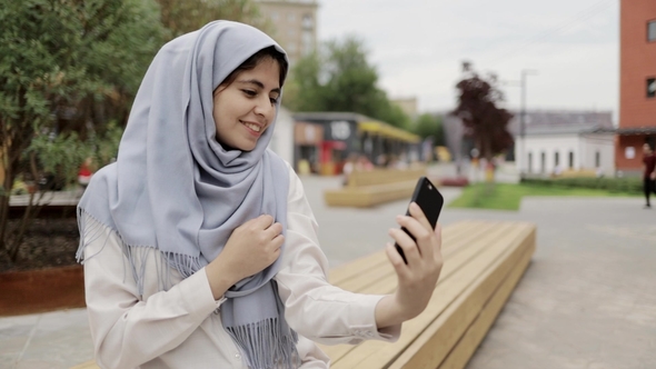 Young Woman in Hijab Making a Selfie in a Summer Street alt