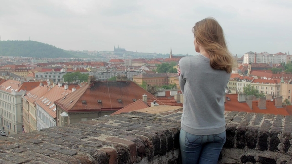 Slim Blonde Woman Is Admiring Panorama of Prague City View in Cloudy Windy Weather