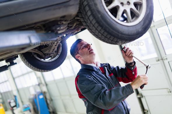 Car mechanic working at automotive service center Stock Photo by nd3000