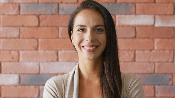 Cheerful Elegant Brunette Near Brick Wall alt