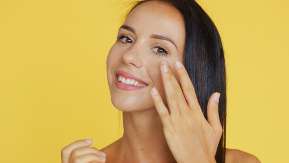 Cheerful Brunette Applying Cream alt