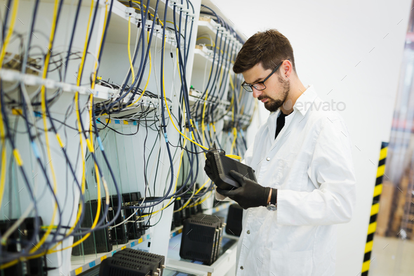 Picture of network technician testing modems in factory Stock Photo by nd3000