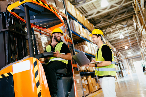 Warehouse workers working together with forklift loader Stock Photo by nd3000