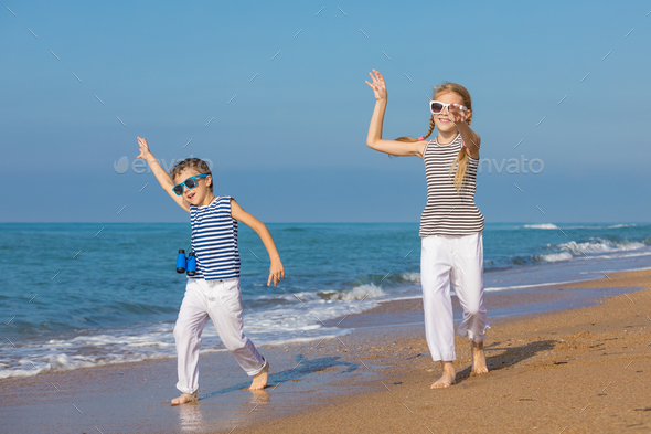 Two happy children playing on the beach at the day time - Stock Photo - Images