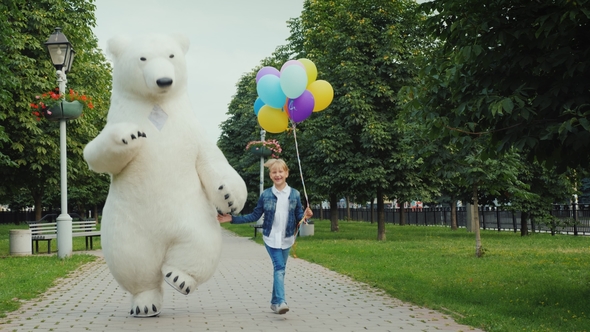 Happy Childhood with Your Favorite Toys, a Big White Bear Is Having Fun with a Child of 7 Years Old alt