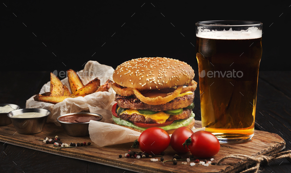Hamburger made of beef and beer on wooden cutting board Stock Photo by Prostock-studio