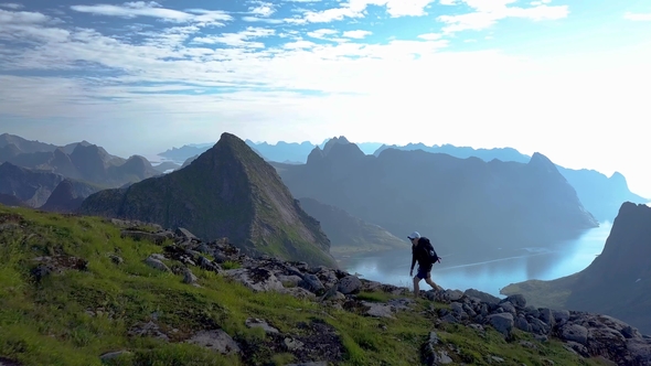Girl with a Backpack Rises on a Mountain Ridge alt