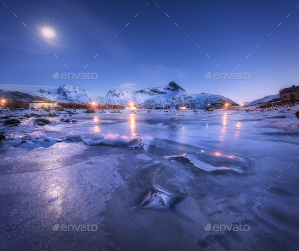 Frozen sea coast, beautiful snow covered mountains and starry sky Stock Photo by den-belitsky