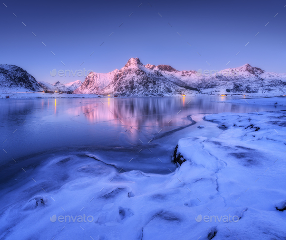 Frozen sea coast and beautiful snow covered mountains at dusk - Stock Photo - Images