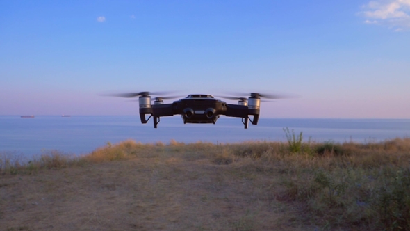 Quadrocopter Flies in Place Against the Background of the Sea UAV in alt