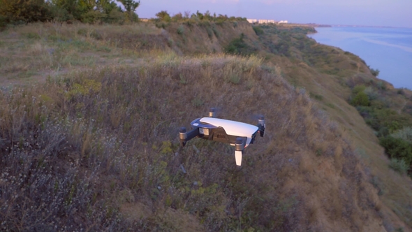 Quadrocopter Flies in Place Against the Background of the Sea alt
