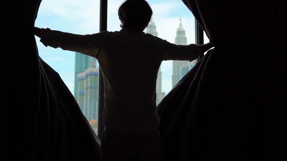 Superslowmotion Shot of a Silhouette of a Successful Rich Man Opening the Curtains of a Window alt