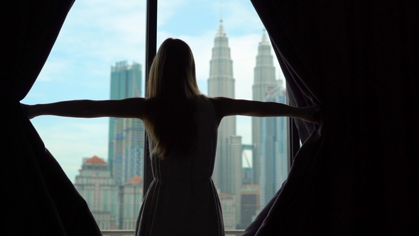 Superslowmotion Shot of a Silhouette of a Successful Rich Woman Opening the Curtains of a Window alt