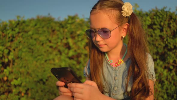 Girl Checking Smartphone Content in a Park alt