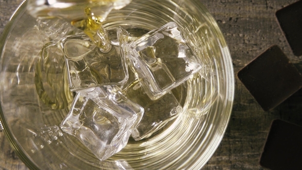 in the Glass with Artificial Ice Pouring Whisky Top View